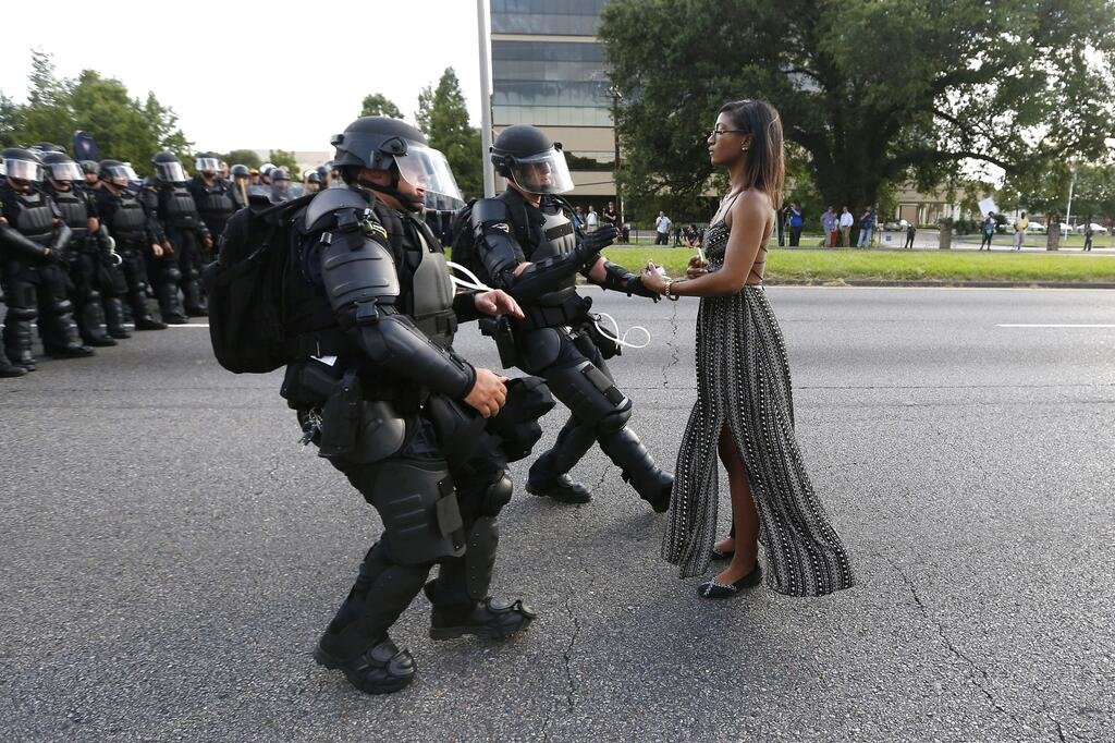 Eine friedlich demonstrierende Frau im Sommerkleid wird von Polizisten in Kampfmontur festgenommen - dieses Bild aus Baton Rouge sorgt weltweit für Schlagzeilen. 