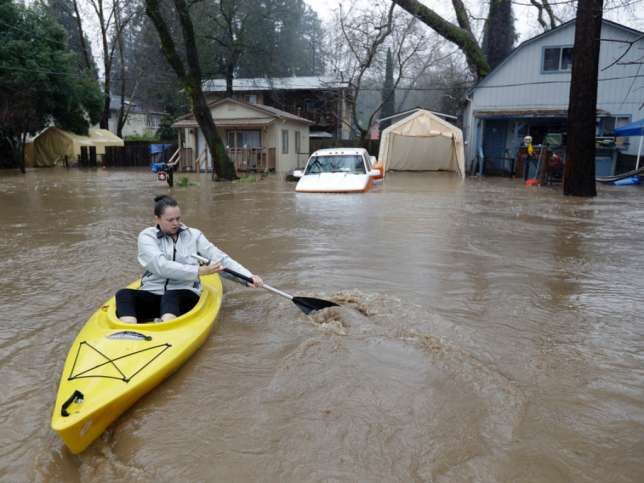 Eine Frau bewegt sich mit einem Kayak durch die überfluteten Strassen von Felton. 