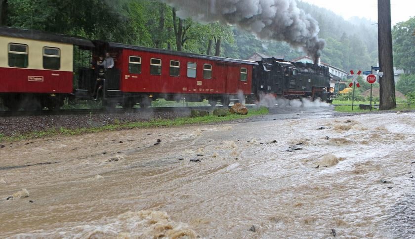 Die Dampflok der berühmten Harzquerbahn schnauft sich ungeachtet der Überflutungen weiter durch das malerische Tal bei Wernigerode.