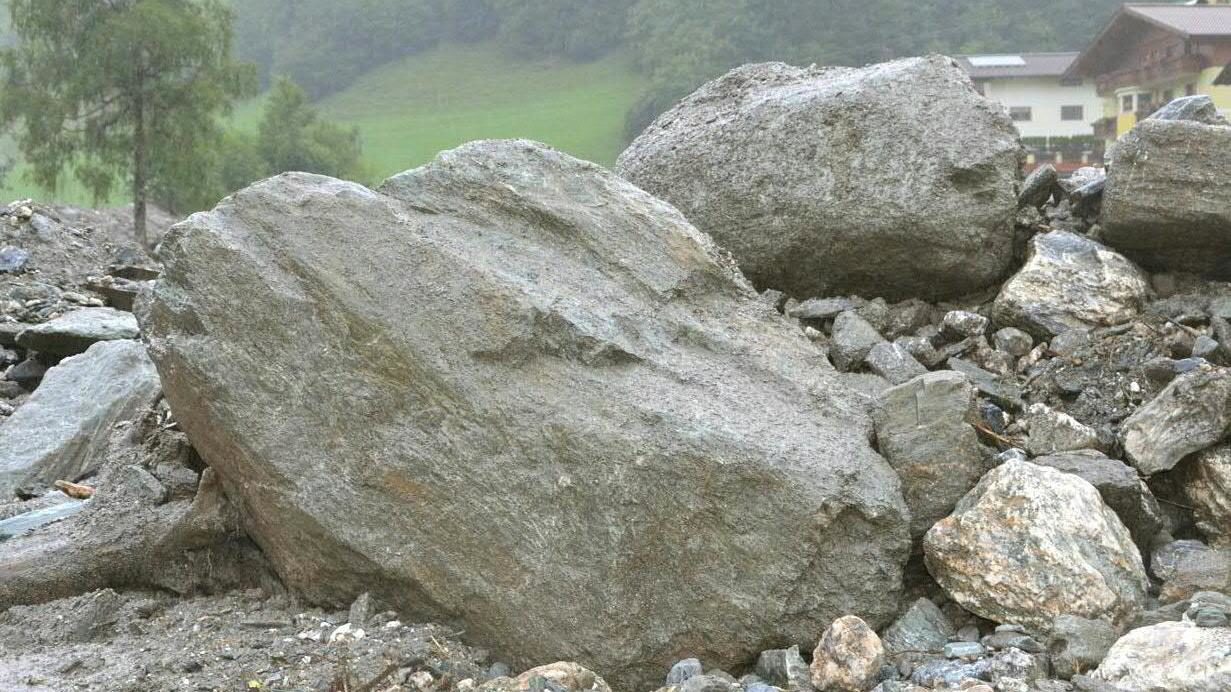 Große Steine liegen am 06.08.2017 in Großarl (Österreich) nach Murenabgängen auf einer Straße. Nach schweren Murenabgängen waren Obertauern und Teile von Großarl nicht erreichbar.